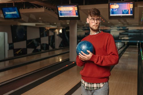 Man in Red Sweater Holding Blue Ball