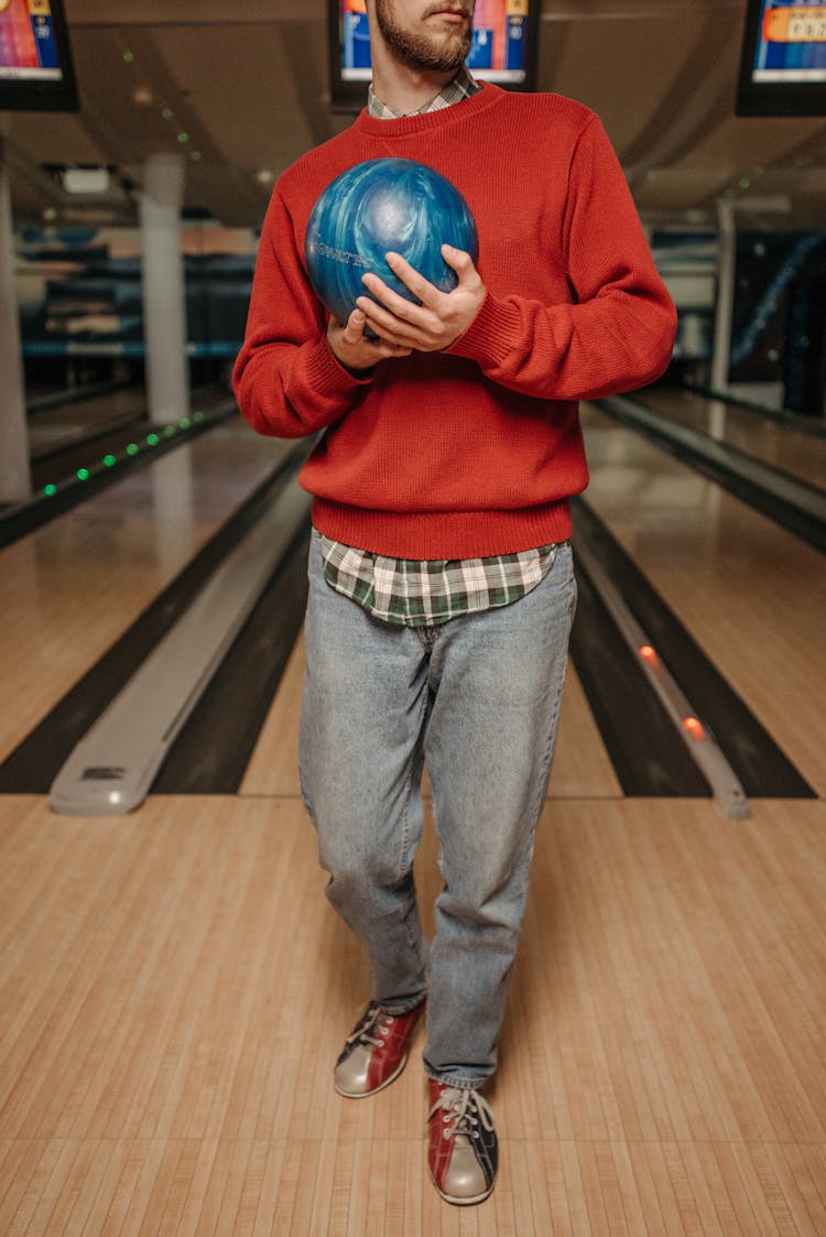 Man In Red Sweater And Blue Denim Jeans Holding Blue Bowling Ball