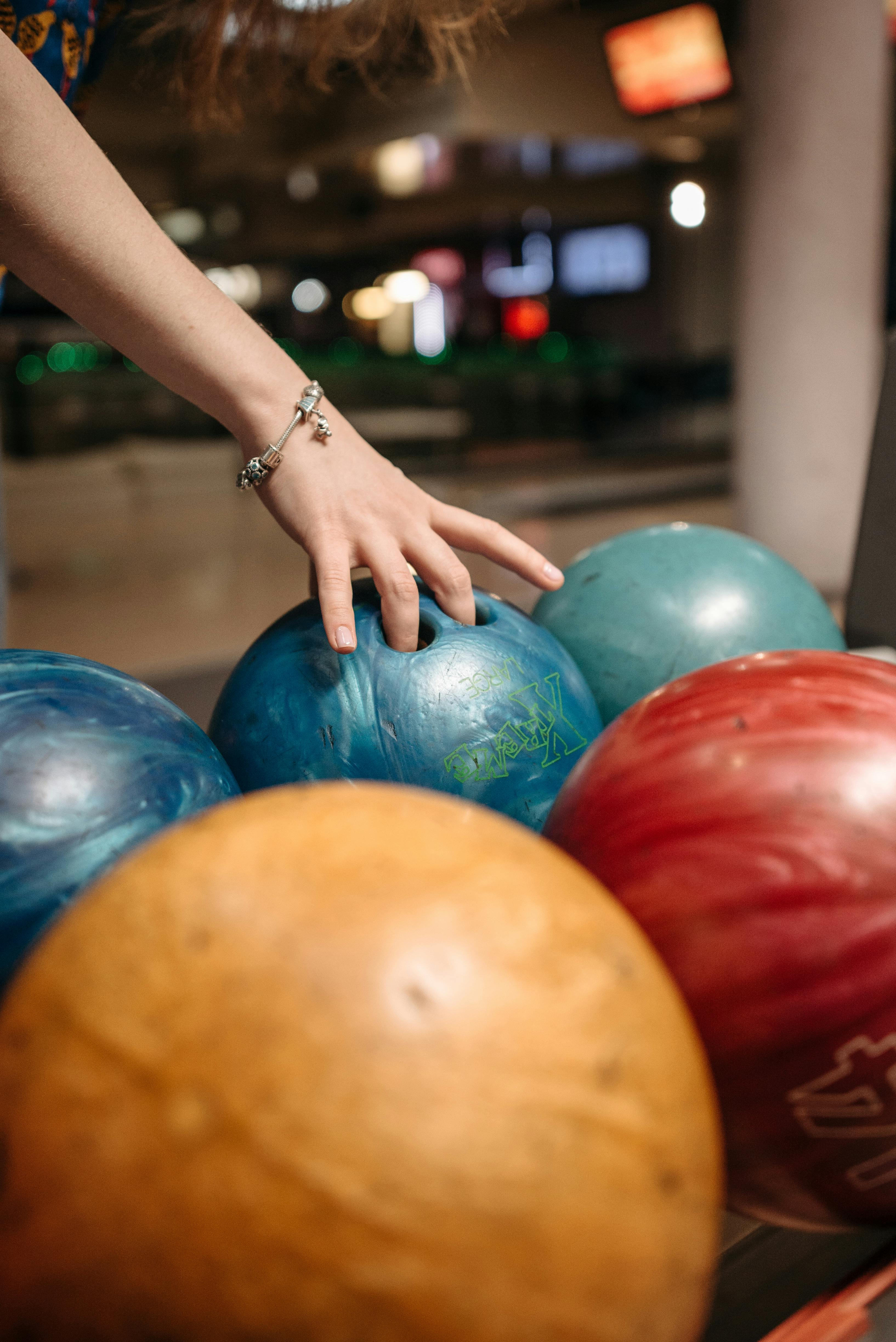 person holding blue bowling ball