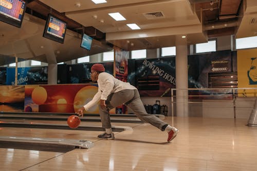 Man in White Long Sleeves and Red Bonnet Playing Bowling