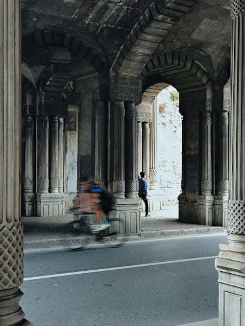 Бесплатное стоковое фото с арки, велосипедист, вертикальный выстрел