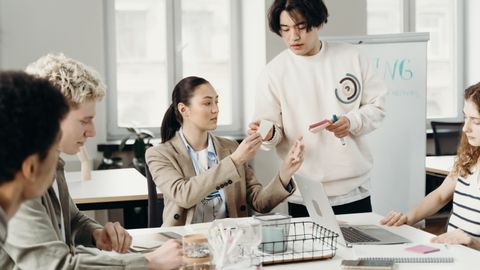 A diverse group of young adults collaborating in a modern office setting, discussing a project.