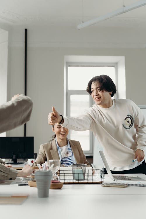 Free Man in White Crew Neck Sweater Giving a Thumbs Up Stock Photo