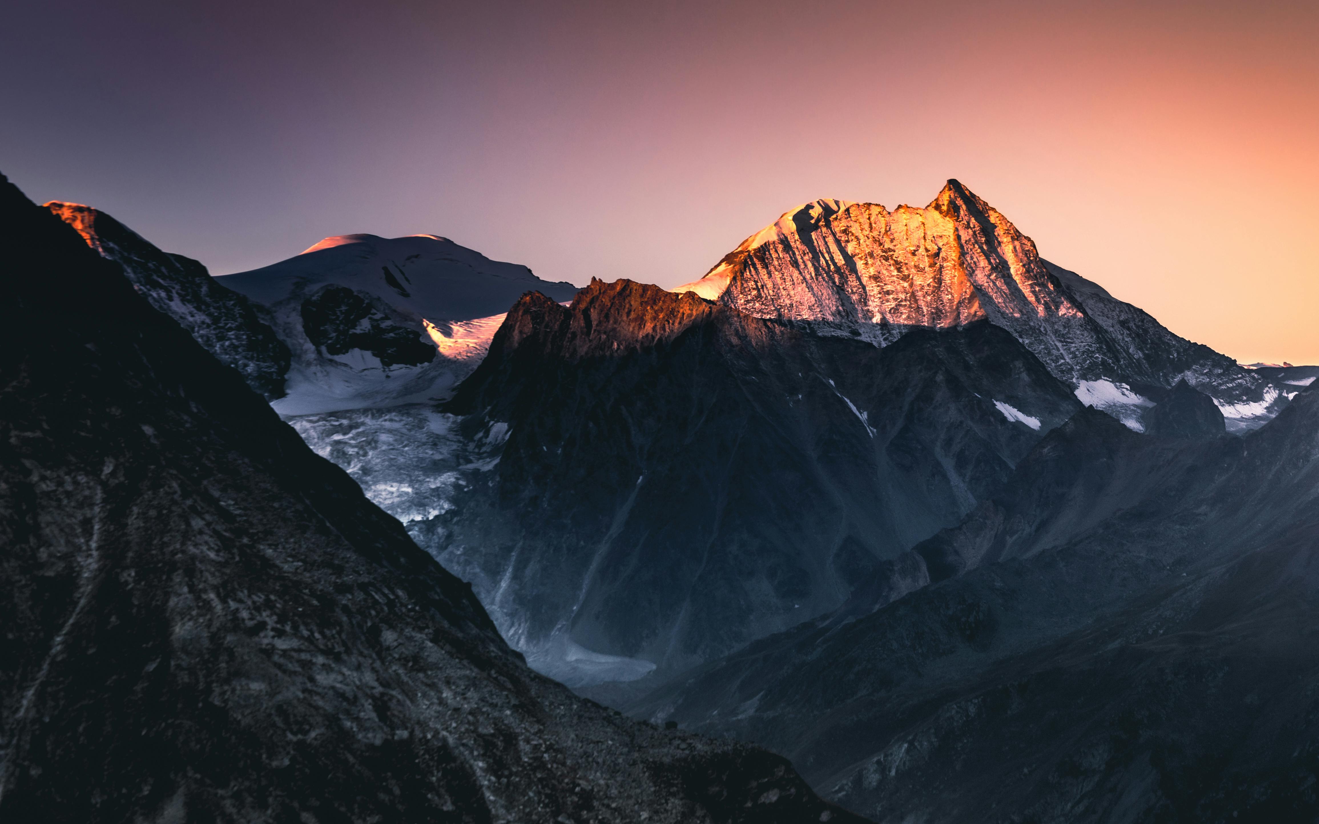 Breathtaking view of Swiss mountains with vibrant sunset glow during winter.