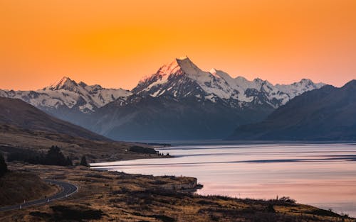 Free Snow-Covered Mountains near Ocean during Sunset Stock Photo