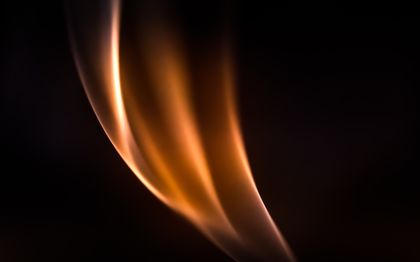 Glowing flame against a dark background, photo by Marek Piwnicki on Pexels