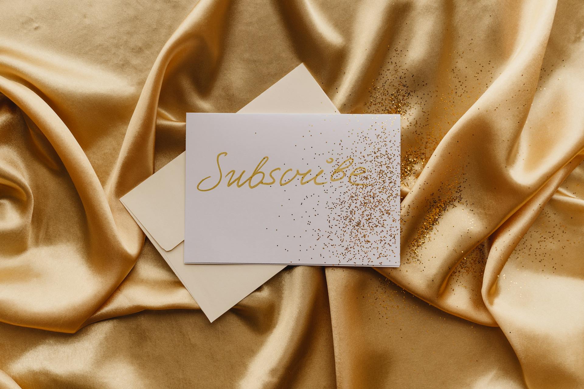 Luxurious card on golden satin with glitter highlights, exuding elegance and style.