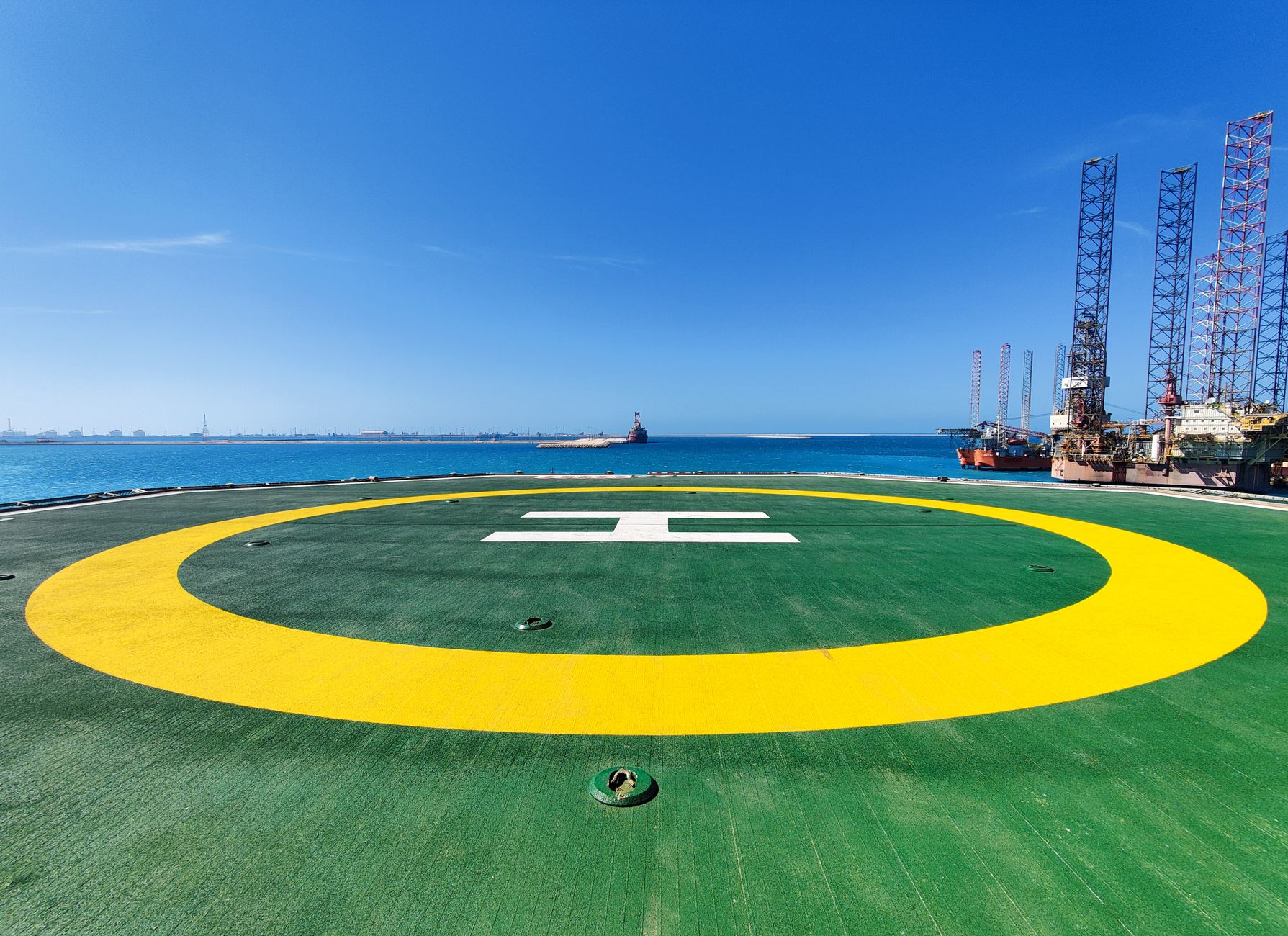 Açık deniz platformuna giden helikopter ve işçiler
