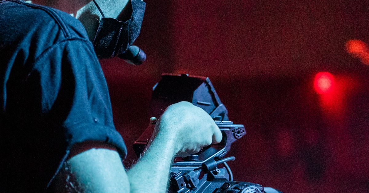 A Camera Operator Holding a Camera · Free Stock Photo