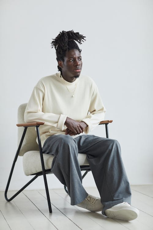 A Man with Dreadlocks Sitting on a Chair