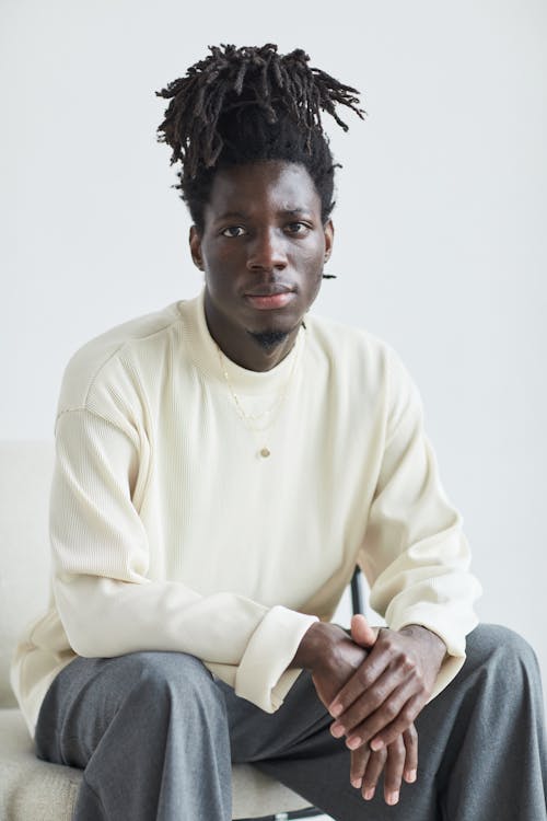 A Man with Dreadlocks Sitting on a Chair