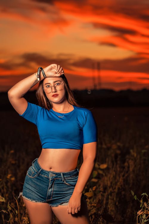 Woman in a Blue Crop Top Posing with Her Hand on Her Head