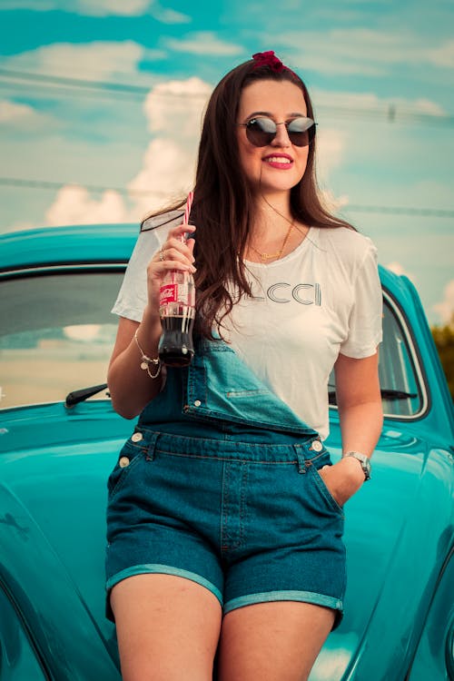 A Woman wearing Sunglasses holding Bottle