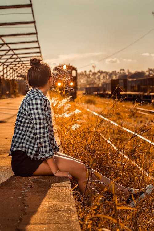 Free A Woman Sitting on the Side of a Railway Stock Photo
