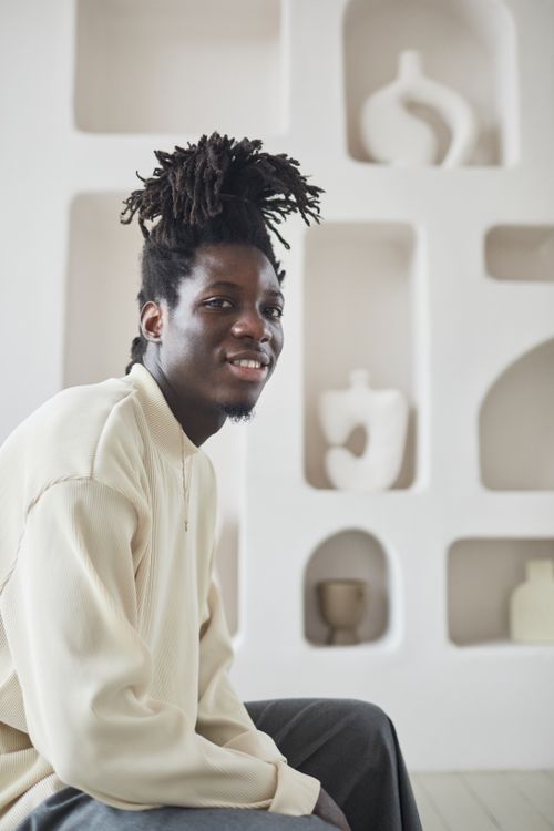Free A man with dreadlocks in a contemporary room with minimalist decor. Perfect for lifestyle and fashion themes. Stock Photo
