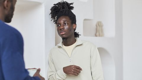 Two men talking and listening in an indoor setting, capturing a moment of engagement and communication.