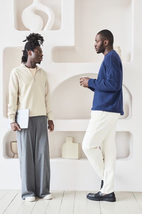 Free Two men having a conversation in a modern, minimalistic indoor setting. Stock Photo