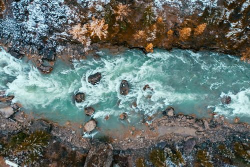 Free Stunning aerial shot of a turquoise river flowing through snowy terrain in Altai, Russia. Stock Photo
