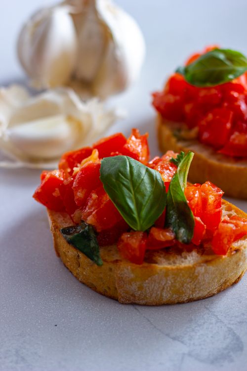 Free Close-up of Italian bruschetta topped with fresh tomatoes, basil, and garlic on bread. Stock Photo