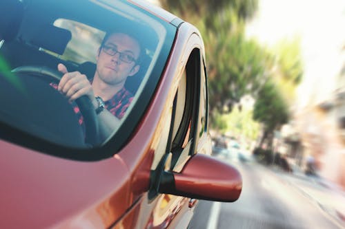 Free Man Driving the Red Vehicle Stock Photo