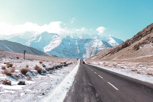 Free Beautiful highway view with snow-covered mountains in winter, perfect for travel and adventure enthusiasts. Stock Photo