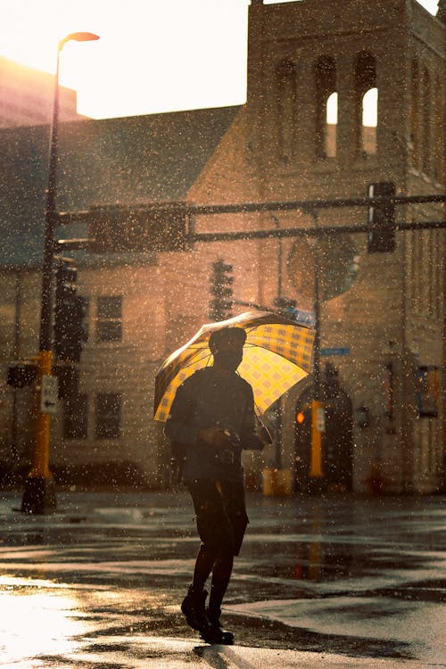 Free A Person Using an Umbrella Stock Photo
