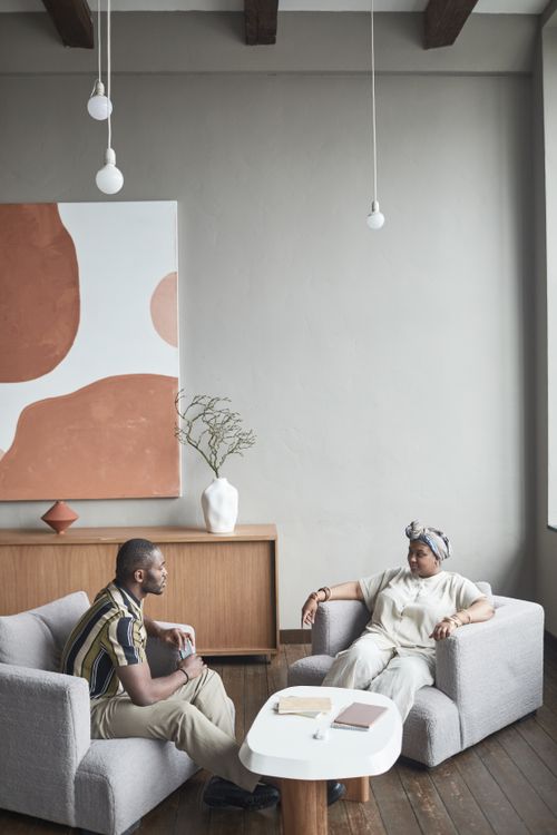 Free A man and woman engaging in a therapy session in a modern, minimalist setting. Stock Photo