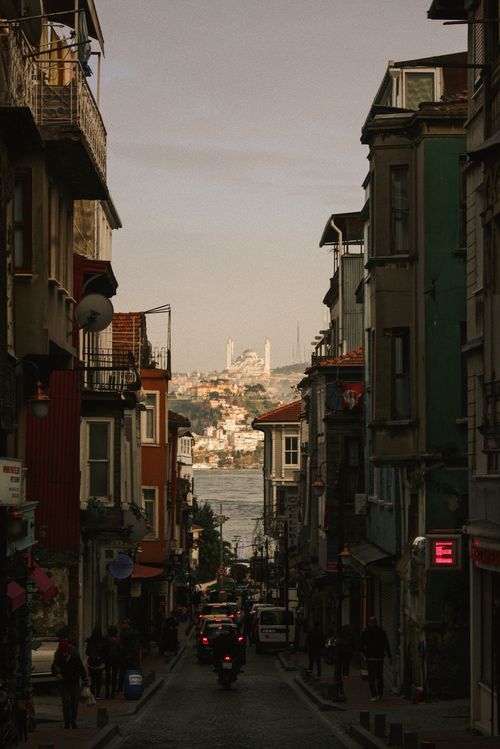 Free Charming street view with colorful buildings and a distant mosque under a tranquil sky. Stock Photo