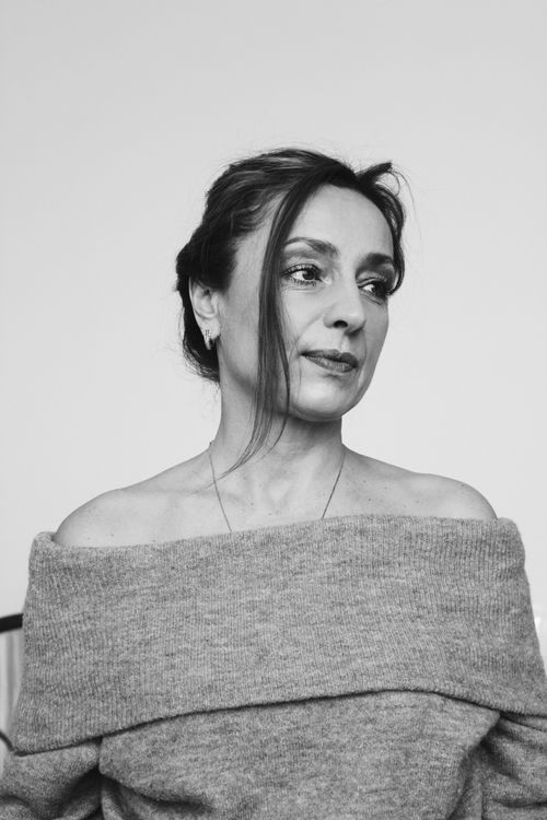 Free Stylish grayscale portrait of a woman in an off-shoulder sweater, creating a fashionable and timeless look. Stock Photo