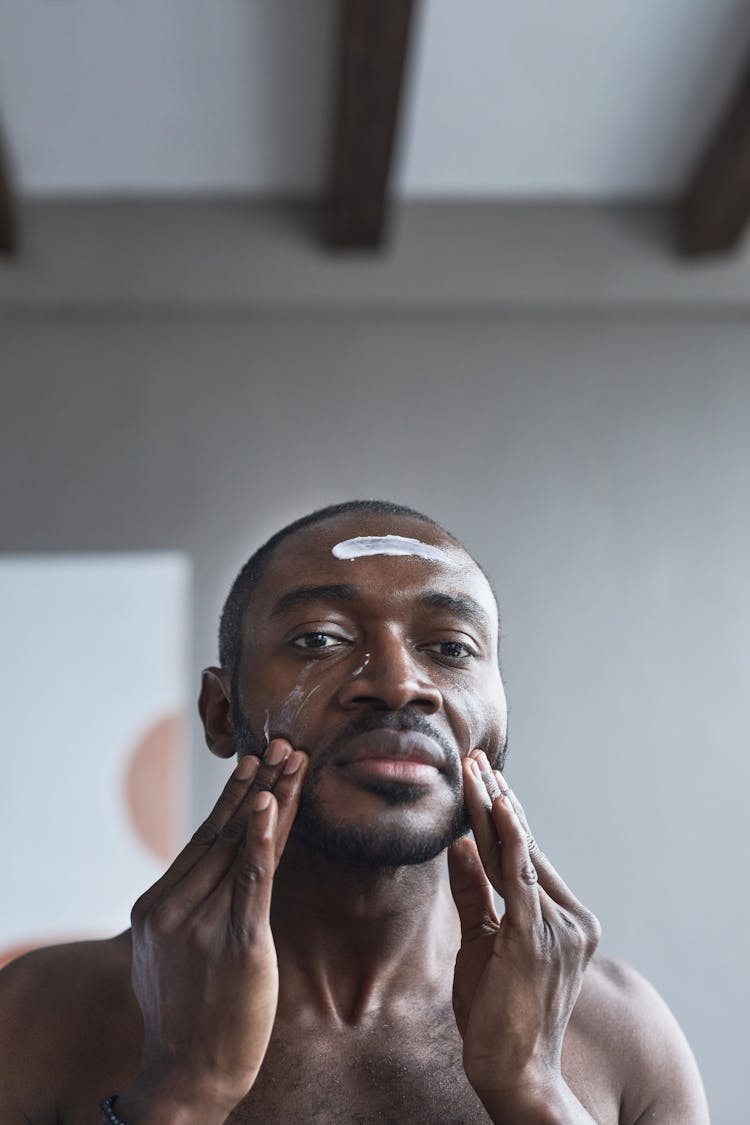 Man Putting On Cream On His Face