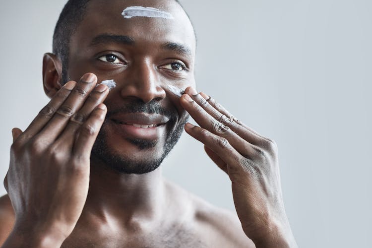 Man Putting On Cream On His Face