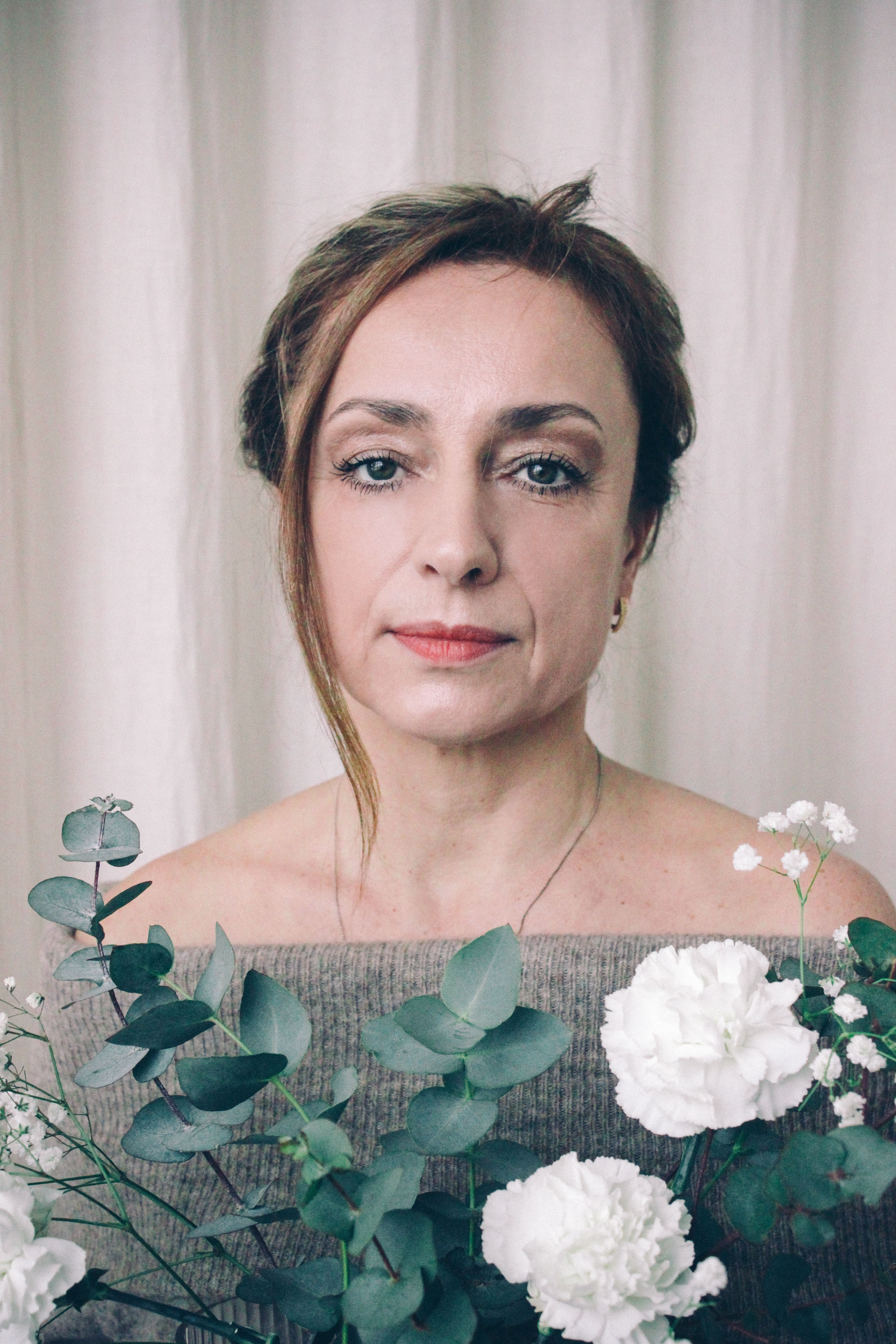 Elegant portrait of a woman with eucalyptus and white flowers, Warsaw.