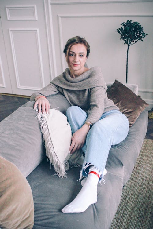 A Woman in Gray Sweater Sitting on the Couch