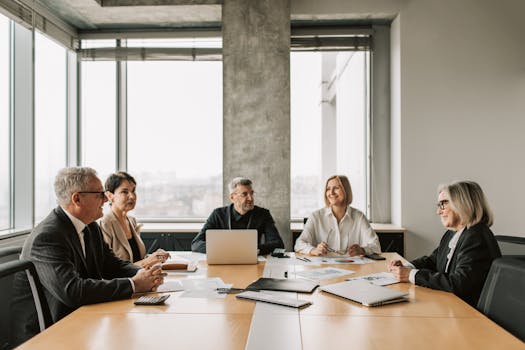 A diverse group of professionals engaged in a business meeting in a modern office.