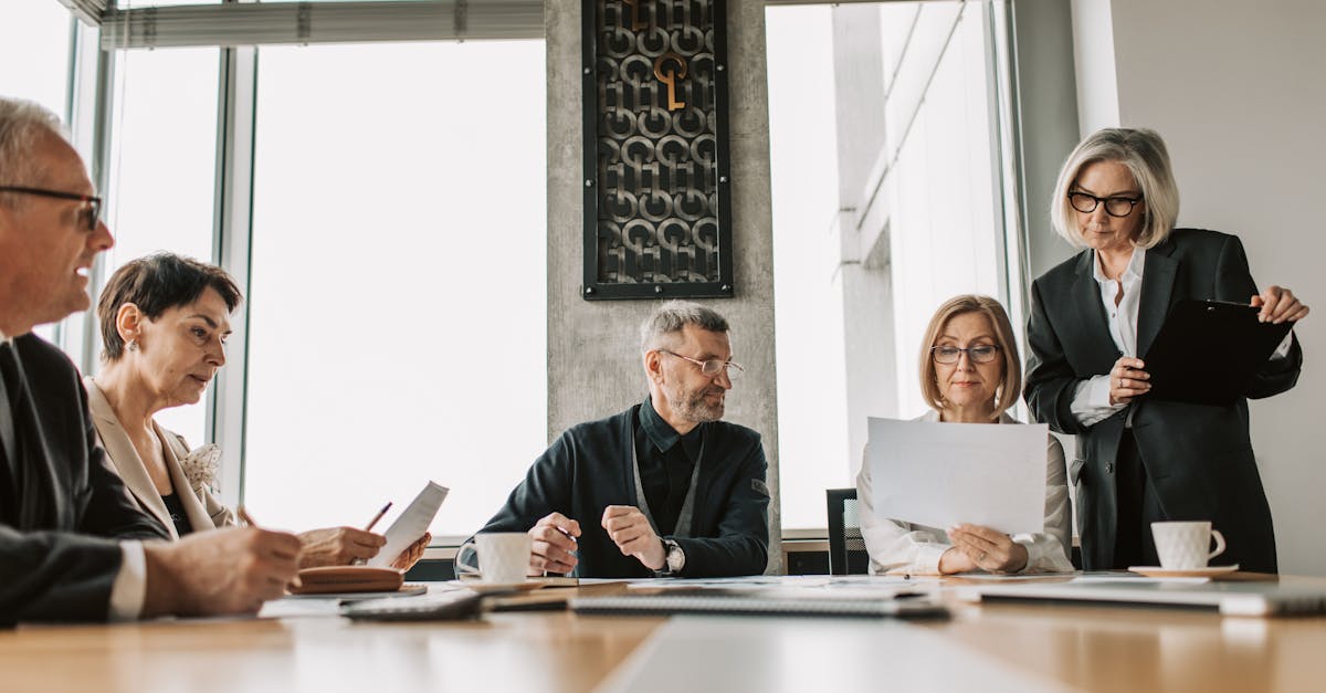 Photo by Vlada Karpovich Business professionals discussing documents in a modern meeting room.