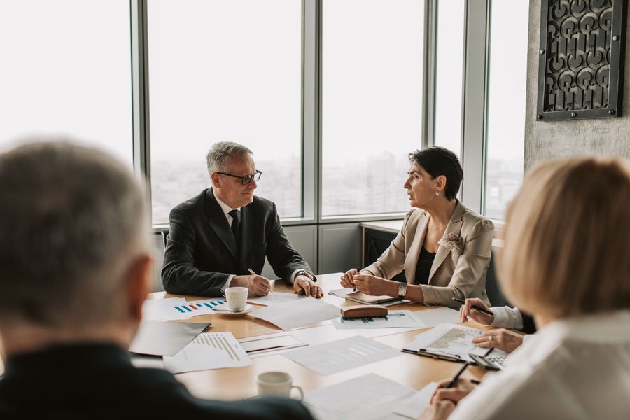 Two senior advisors reviewing a family's succession strategy at the Steward & Legacy office