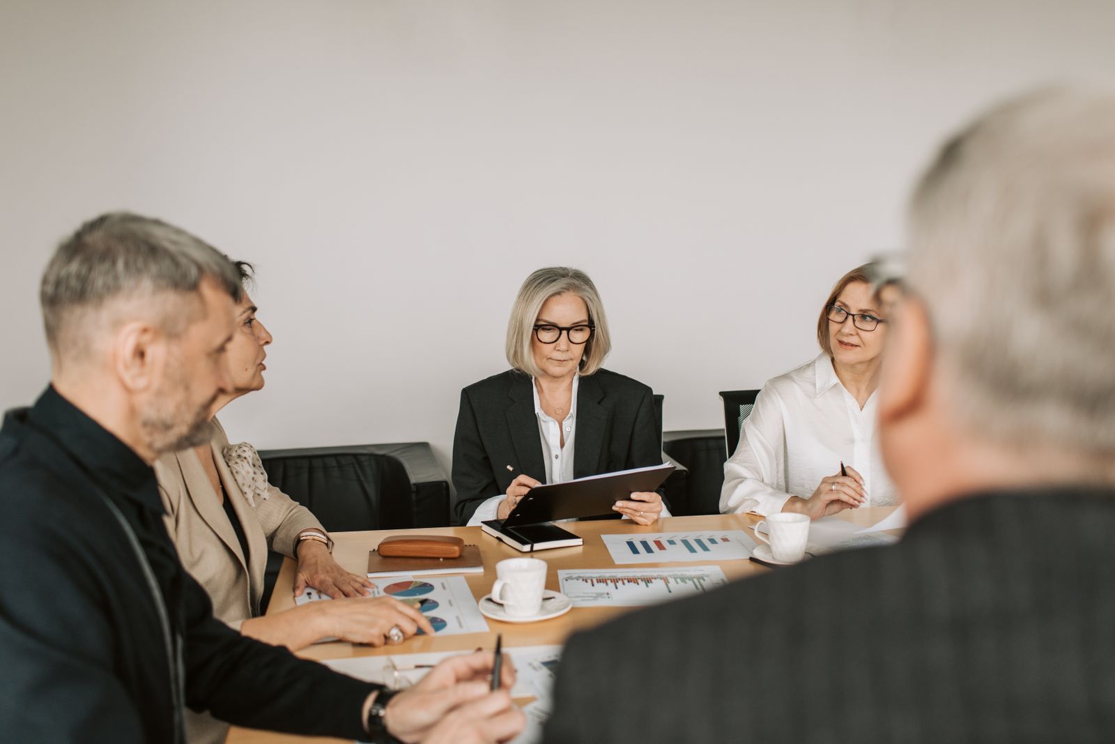 Senior business leaders reviewing plans and data together in a modern office