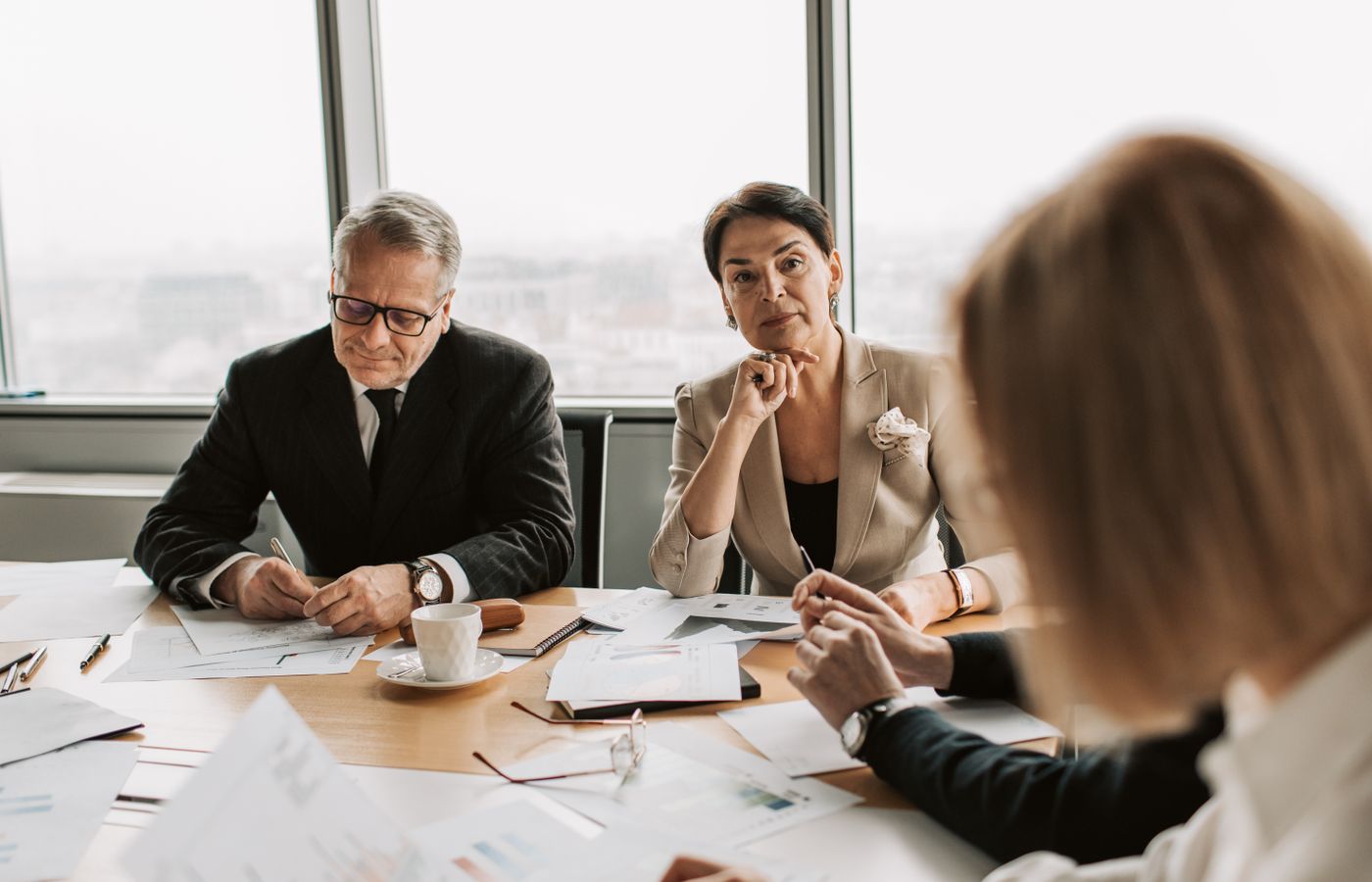 Business professionals in discussion during a meeting in a modern office setting.