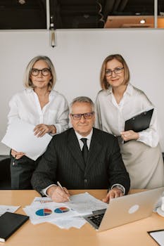 A group of senior business professionals collaborating in an office setting.