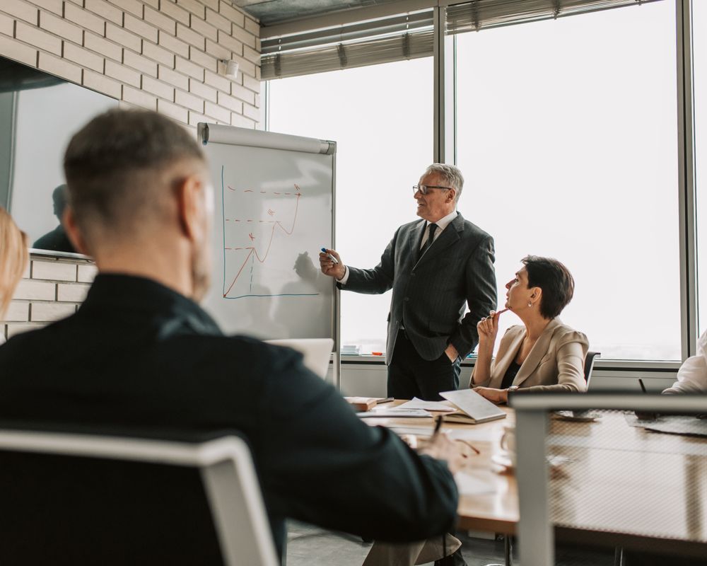Senior leader presenting performance charts to colleagues in a modern boardroom