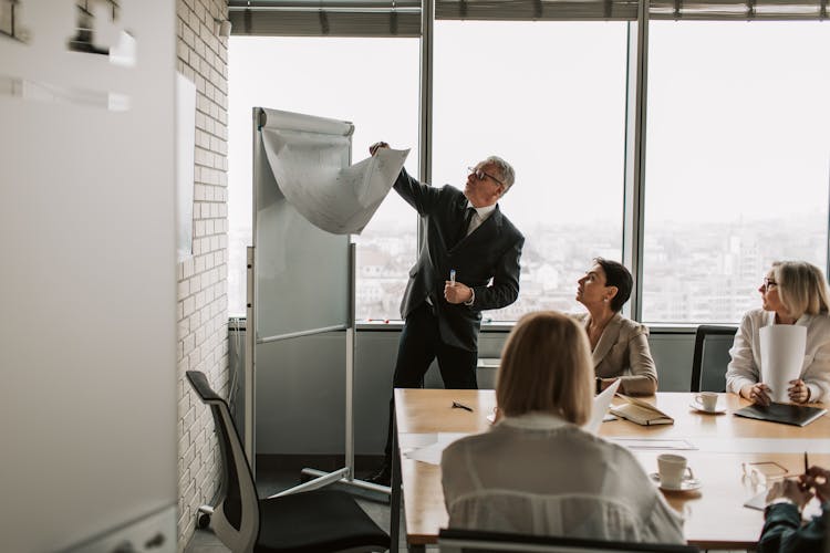 Man In Black Suit Flipping The Paper On The Whiteboard 