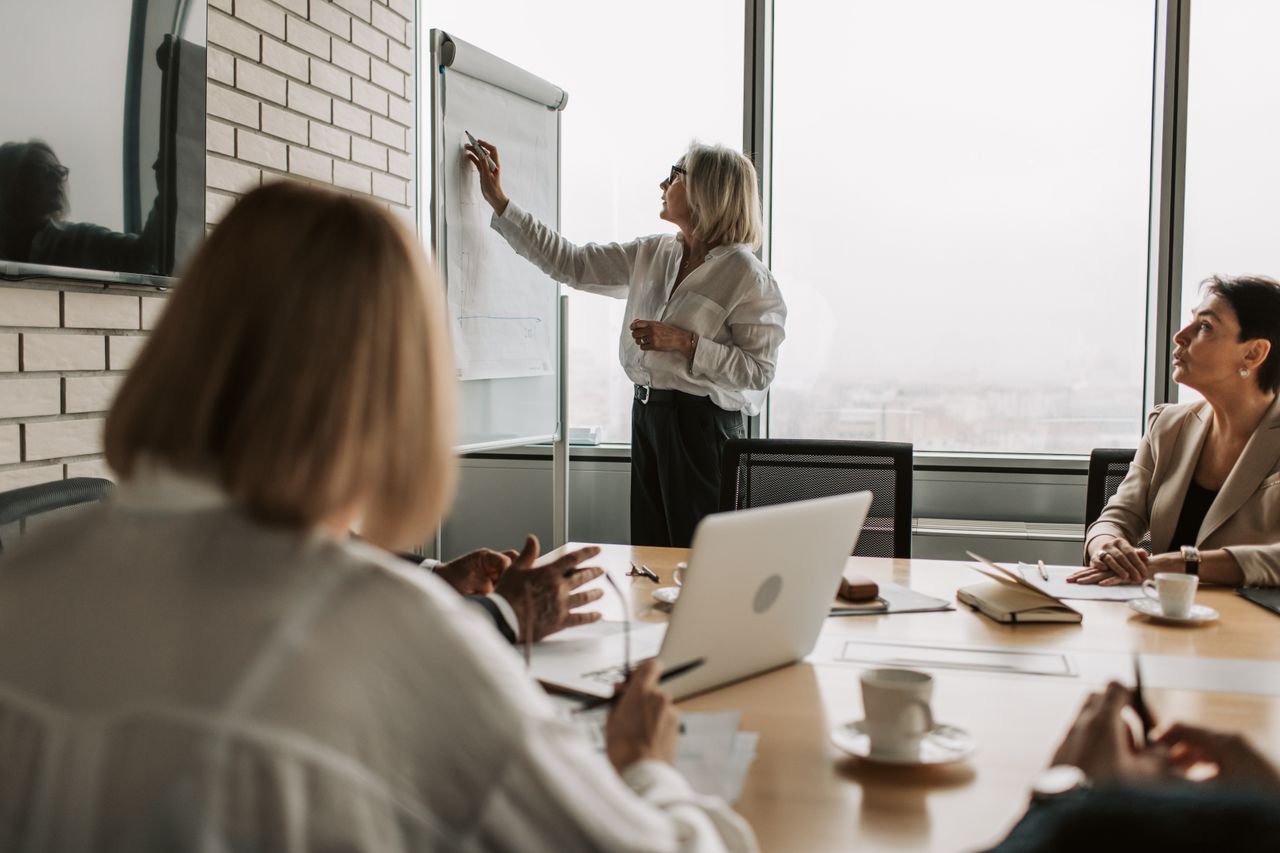 Executive presenter working through a business plan with colleagues in a real office