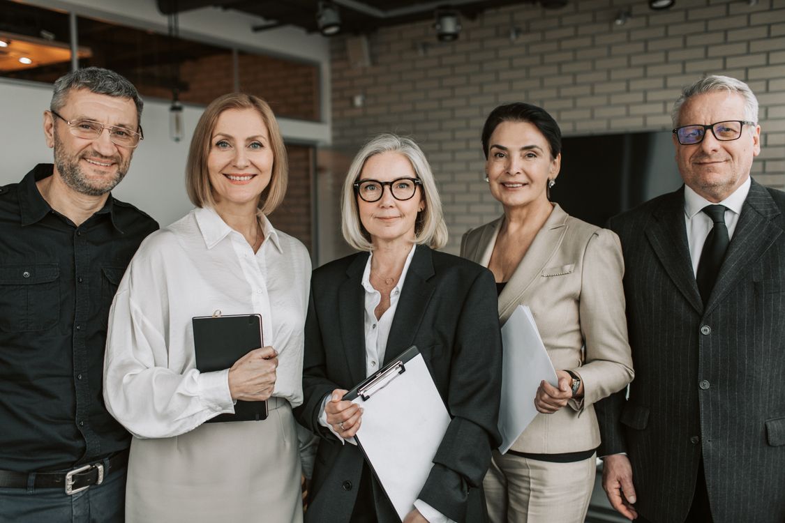 Smiling team of five professionals in an office