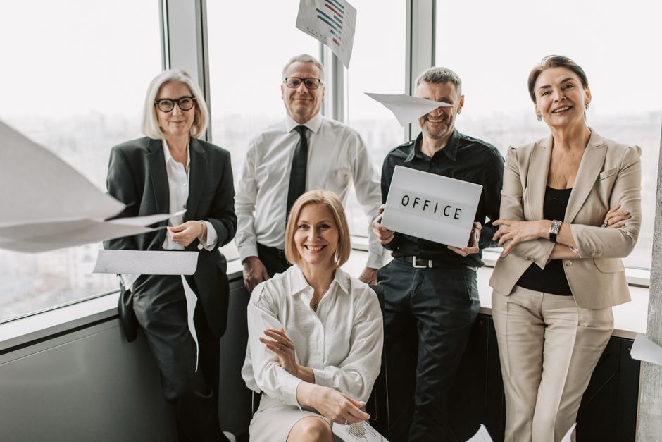 Group of business professionals celebrating achievements inside a modern office space.