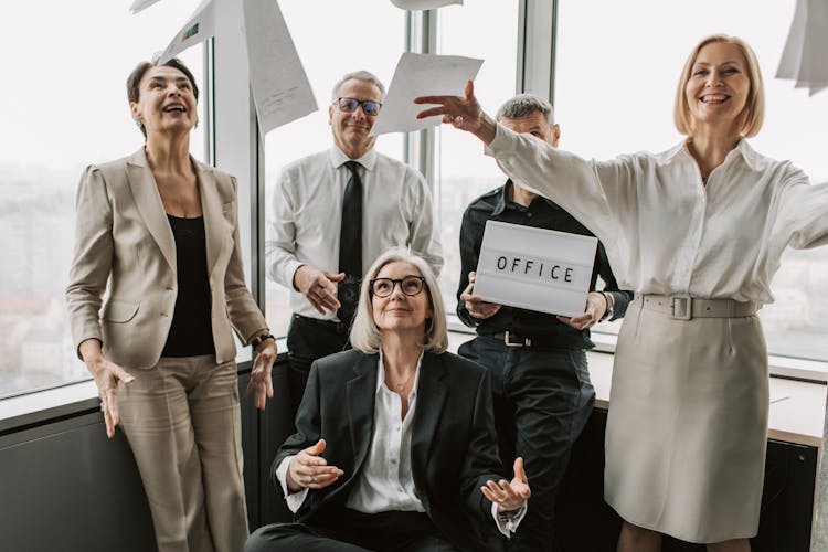 Photo Of Men And Women Throwing Paper