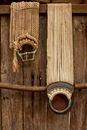 Shabby linen rope belts with rusty buckles hanging on grungy wooden fence in countryside