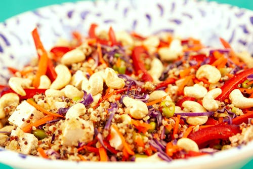 Closeup bowl of vegetarian salad made of couscous and pepper with cashew and tofu