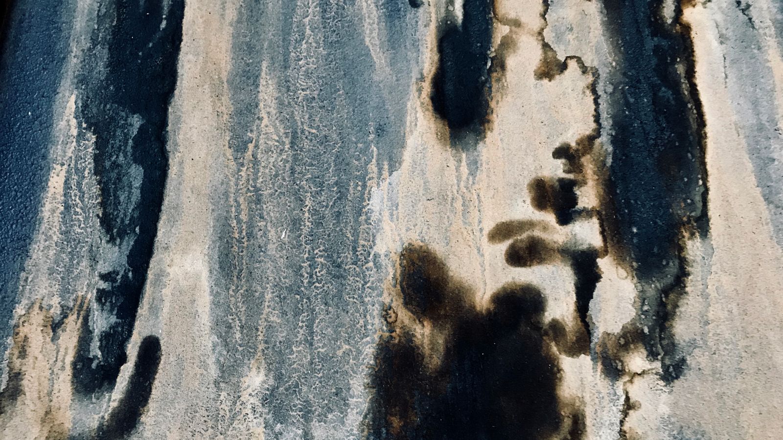 Détail d'un mur ancien marqué par des taches sombres de moisissure et un enduit dégradé.
