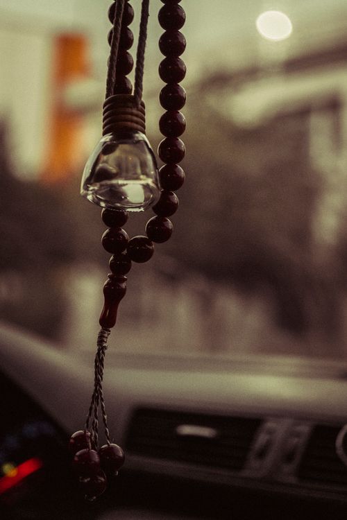 Free Close-up of beads and decorative hanging in a car, evoking travel and spirituality. Stock Photo