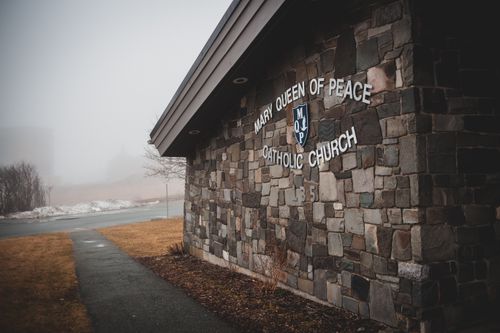 Free Aged stone abandoned building of catholic church located in distant suburb area in foggy day Stock Photo